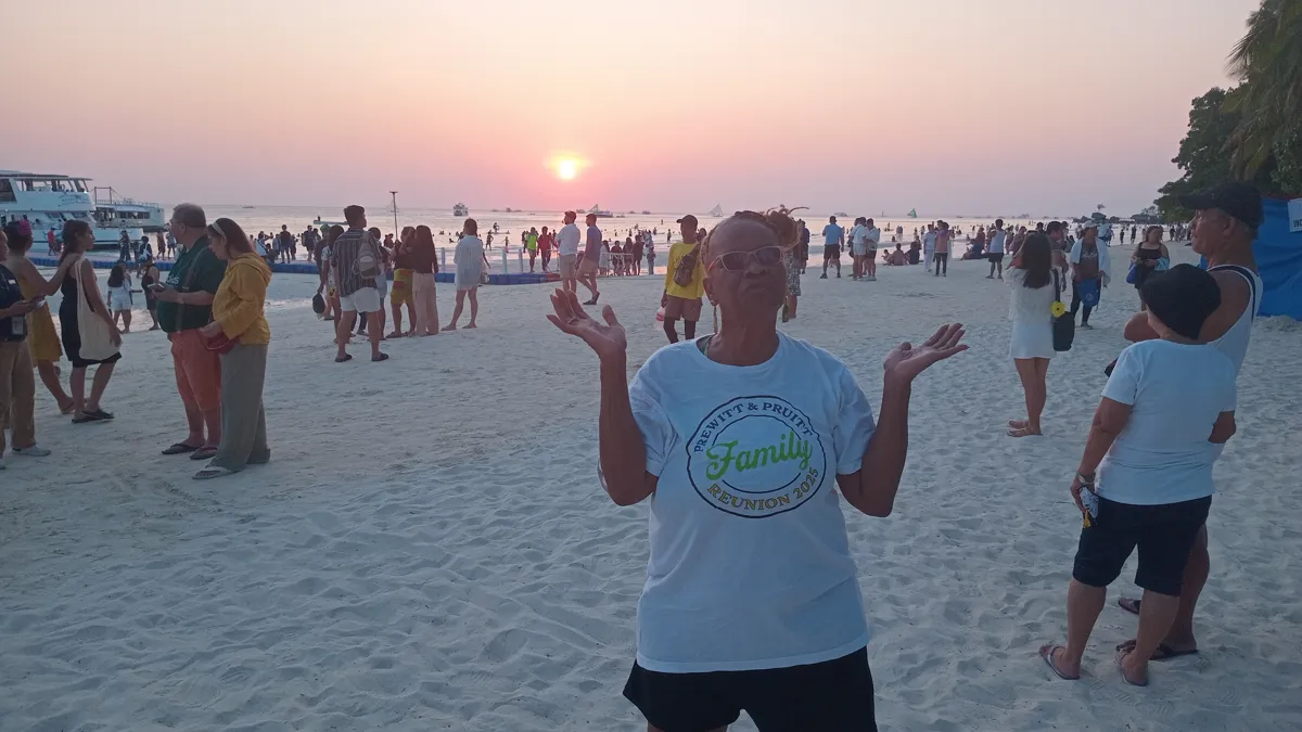 Travelers enjoying a sunset on a busy beach