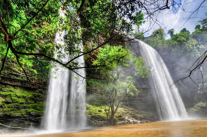 Waterfall cascading over a rocky ledge surrounded by green trees
